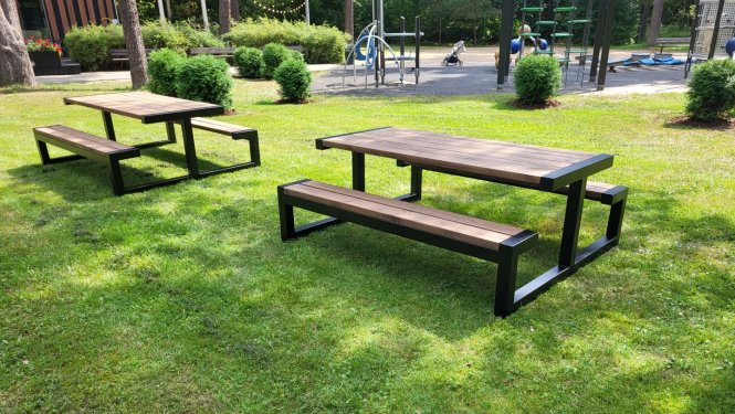 Attēls ar SIA “AFREK” Mežaparka atpūtas teritorijā izstrādātajām dizaina masīviem āra galdiem