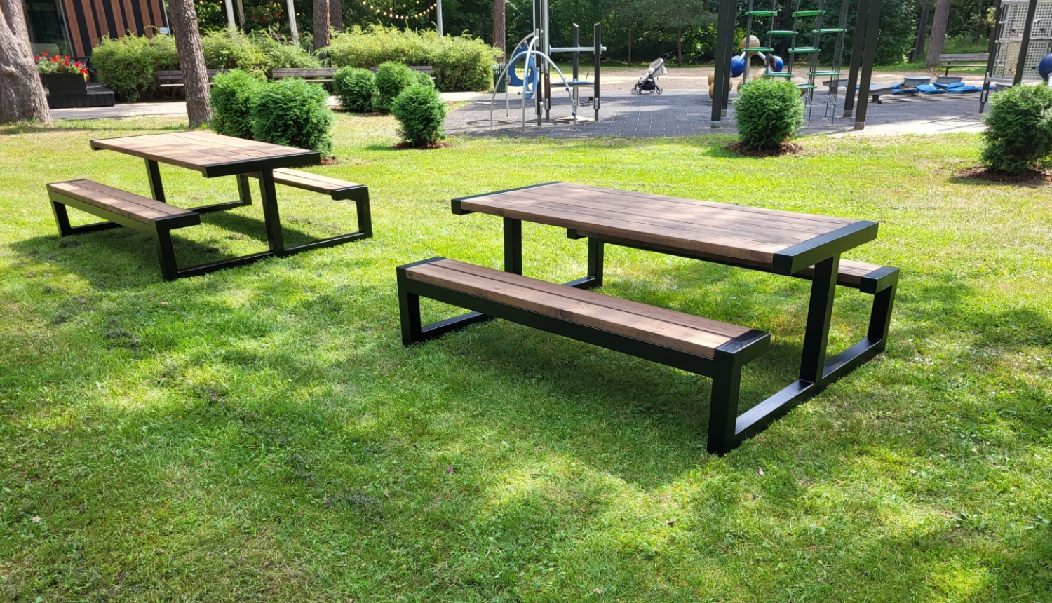 Attēls ar SIA “AFREK” Mežaparka atpūtas teritorijā izstrādātajām dizaina masīviem āra galdiem